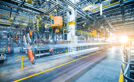 Eine industrielle Umgebung mit verschiedenen Maschinen, Rohren und Förderanlagen, die alle miteinander verbunden und in Bewegung sind.