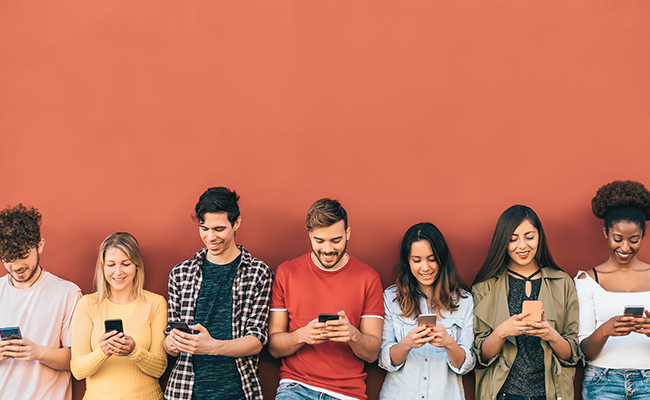 Eine Gruppe von sieben Personen, die alle in ihr Smartphone vertieft sind, vor einem roten Hintergrund.